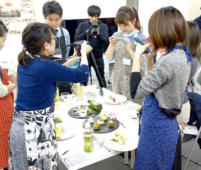 その場で撮影する参加者（富永貿易／ｍｏｇｏｏ）