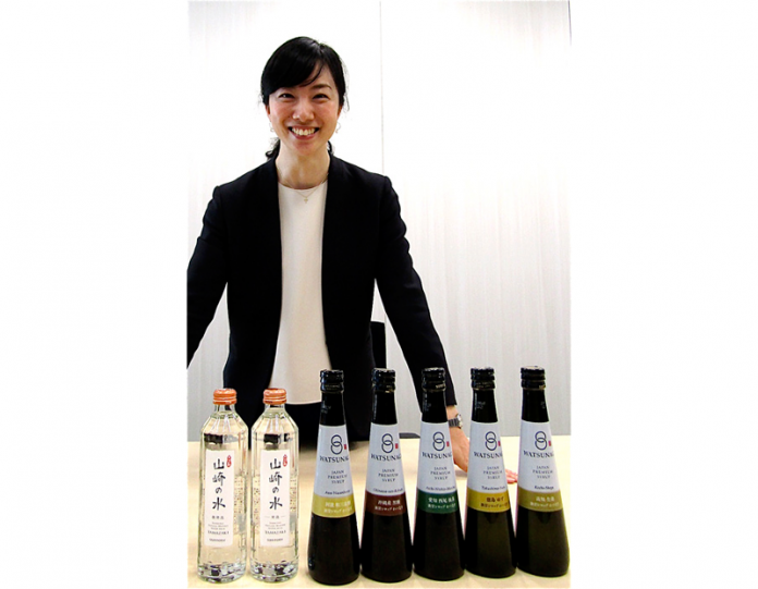 「わつなぎ」（５種・右）と「山崎の水」（２種）を前に根岸美海子氏（サントリー食品インターナショナル）