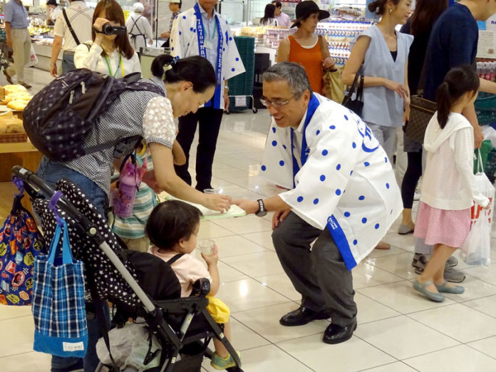 親子に話しかける岸上克彦社長（アサヒ飲料）
