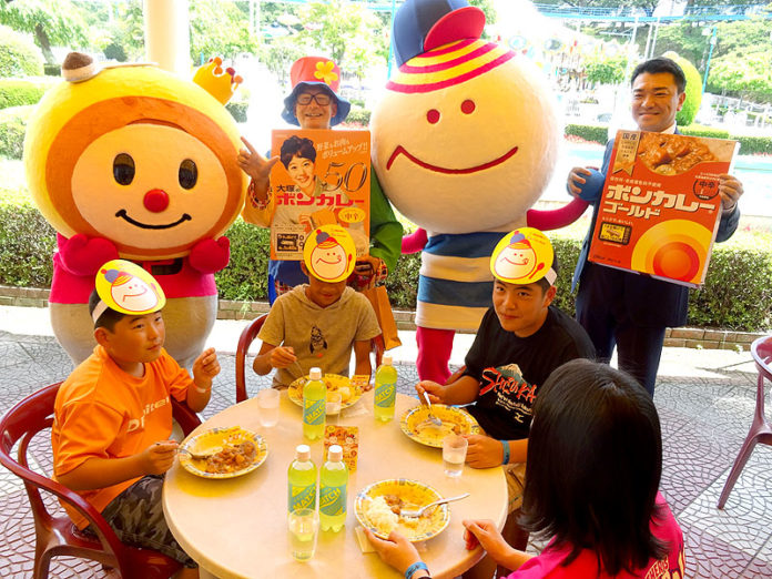 ボンカレーキャラクターのボン王子、八木充幸園長（エイトリー）、ベニ―ランドキャラクターのベニーニョ、細川真志郎支店長（大塚食品）の前でカレーを楽しむ家族