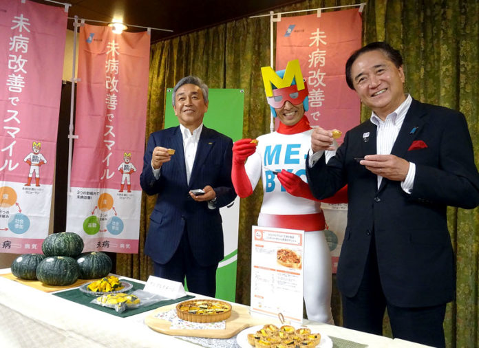 野菜を使った食品を試食する（左から）寺田直行社長（カゴメ）、ミビョーマン、黒岩祐治知事（神奈川県）