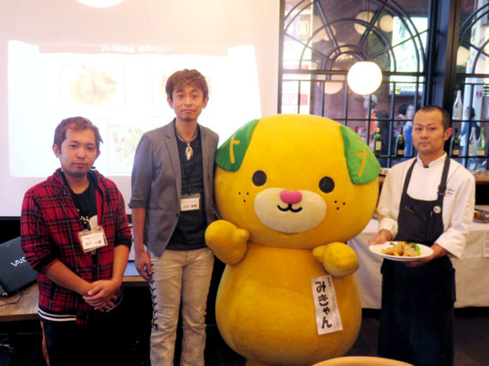 愛媛県のキャラクターの「みきゃん」とフェア参加の飲食店主（媛っこ地鶏ＰＲフェア）