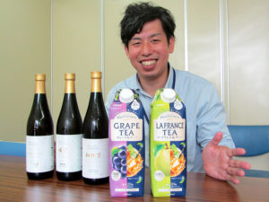 「日東紅茶 フルーティーリッチ」シリーズと瓶製品をアピールする米澤洋朗氏(三井農林)