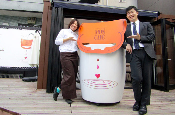 巨大オブジェを囲む藤原啓史主任㊨と「モンカフェ マイスター」（１杯50円！究極のセルフカフェ 恵比寿コンテナ）