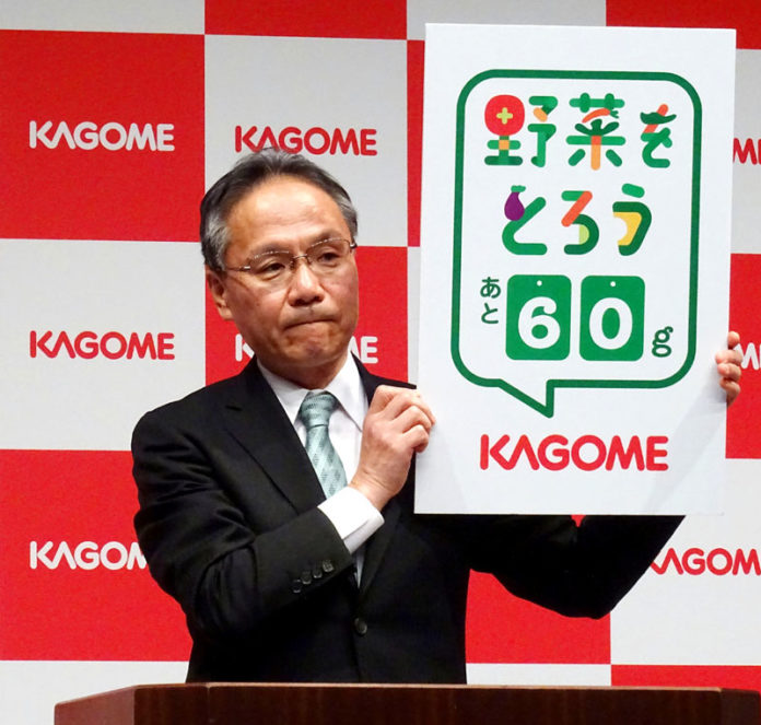 ロゴを掲げる山口聡社長（カゴメ）