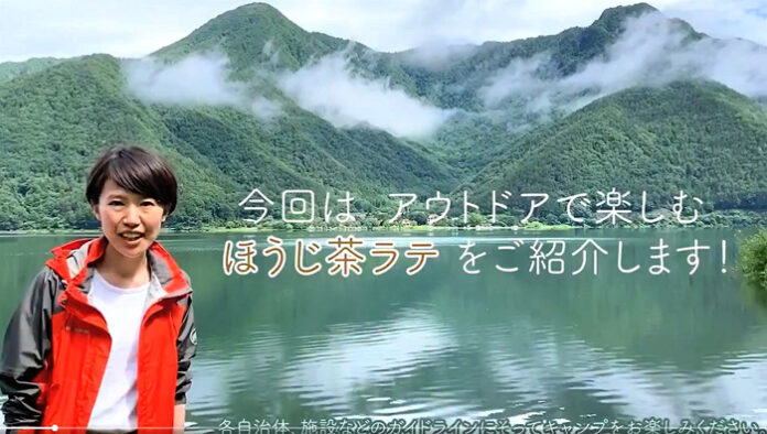 湖畔のキャンプ場を舞台にアウトドアグッズを用いてほうじ茶ラテのつくり方を紹介するマーケティング本部販売促進部第六課の西原佐栄さん。（伊藤園）