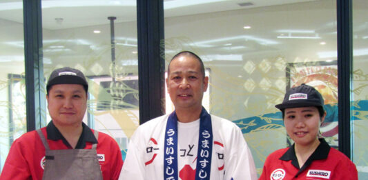 あきんどスシローの堀江陽社長㊥とボウリングシャツ風の限定ユニフォームを着たスタッフ