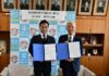 調印式で南出市長（左）と雜賀社長
