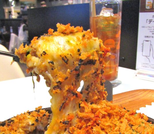 「デイヤ」初上陸第一弾メニューとなる「デイヤ×2foods 焼きチーズカレー」にスプーンを入れチーズが伸びる様子