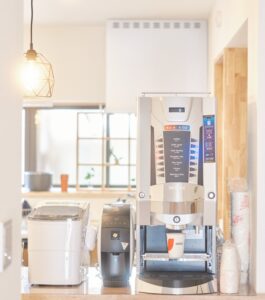 コーヒーメーカー「ネスカフェ ゴールドブレンド バリスタ」（中央）と業務用ディスペンサーマシン（右）