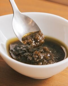 日本人に合う味わいを目指して開発。さわやかな香りと辛みが特徴の青唐辛子に、タマネギ、ショウガ、ニンニク、アンチョビを原料に使用している。 - 食品新聞 WEB版（食品新聞社）