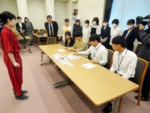 宇佐見さん㊧の説明でゲームを体験する学生と局員 - 食品新聞 WEB版（食品新聞社）