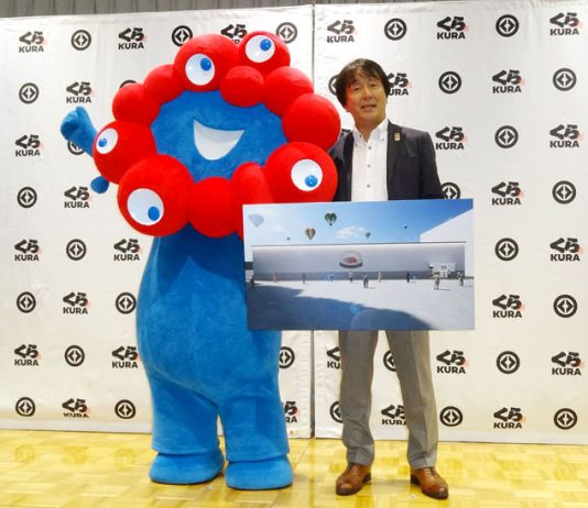 会見した岡本浩之取締役。万博公式キャラのミャクミャクとともに