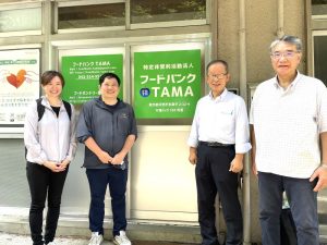 フードバンクTAMA入り口で特定非営利活動法人フードバンクTAMA理事事務局長の芝田晴一朗さん（中央右）、手嶋さん（左）、中前さん（中央左）、渡邊さん（右） - 食品新聞 WEB版（食品新聞社）