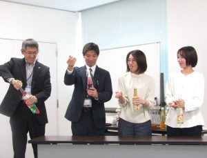 開栓を実演するトンボ飲料の社員。思わず笑顔がこぼれる。 - 食品新聞 WEB版（食品新聞社）