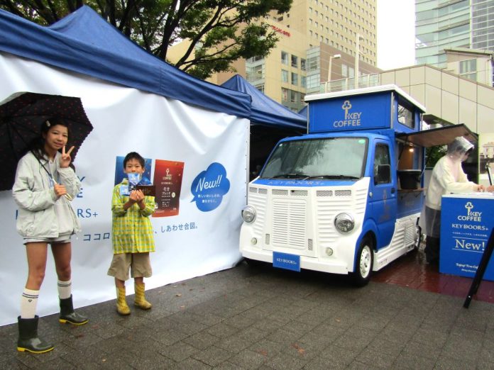 JR桜木町駅前（神奈川県横浜市）のイベント会場。「KEY COFFEE TRUCK（キーコーヒートラック）」（右）と抽選会の景品やサンプリング品を手にする子ども