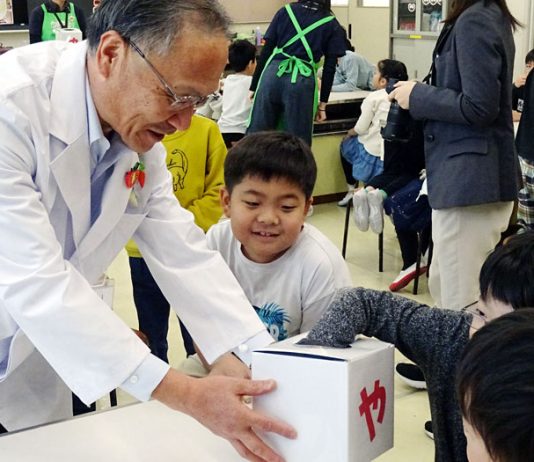 小学生に箱の中の野菜を触ってもらい、何の野菜かを当てるクイズを山口社長自ら出題