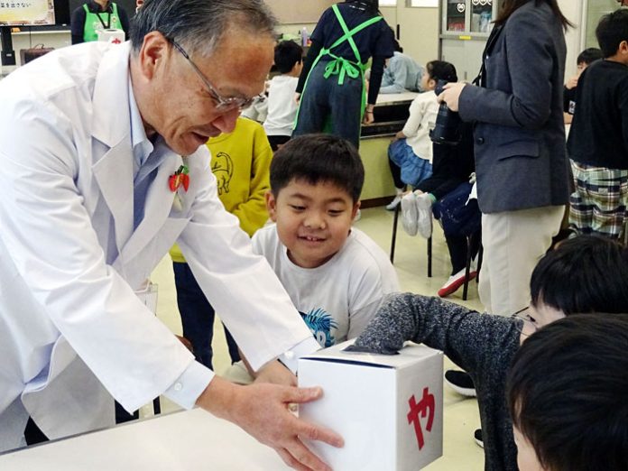 小学生に箱の中の野菜を触ってもらい、何の野菜かを当てるクイズを山口社長自ら出題