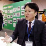 100年の歴史を伝える写真の前で山下喜一郎社長