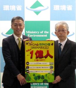 明治の萩原秀和執行役員グローバルカカオ事業本部長左から宣言ボードを手渡された環境省の植田明浩自然環境局局長 明治の萩原秀和執行役員グローバルカカオ事業本部長(左)から宣言ボードを手渡された環境省の植田明浩自然環境局局長