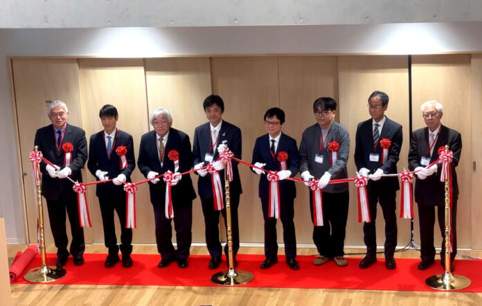 「邂逅館」開所式　テープカットの様子（左から4人目 千葉一祐学長 その他左から 　安達健氏（オーストラリア・クイーンズランド州政府駐日代表） ／春名展生氏（東京外国語大学学長） ／田野俊一氏（電気通信大学学長） ／千葉学長／井上諭一氏（文部科学省科学技術・学術政策局局長） ／三浦卓也氏（良品計画ソーシャルグッド事業部地域事業担当 部長） ／瀬川 勲氏（株式会社ANALOG 代表取締役社長） ／生島和正氏（武蔵エンジニアリング株式会社 代表取締役社長））