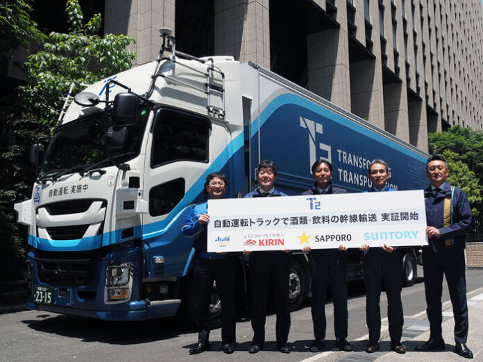 自動運転トラックの前で参加企業トップら