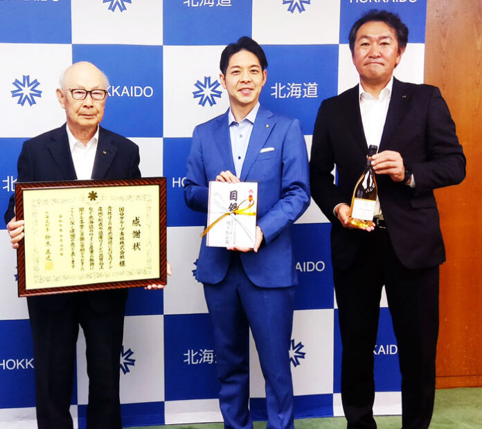 鈴木直道知事㊥から感謝状を贈られた国分G本社・國分勘兵衛会長㊧、国分北海道・諏訪勝巳社長