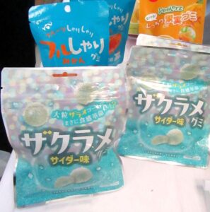 フルしゃりグミ みかん左奥とザクラメグミ サイダー味手前 「フルしゃりグミ みかん」(左奥)と「ザクラメグミ サイダー味」(手前)