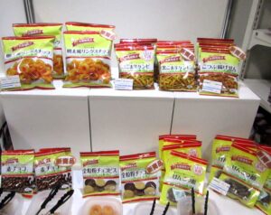 「お買い得気分」の新商品。上段左から「明太風リングスナック」「黒ごま辛ケンピ」「こつぶ揚げせん」、下段左から「麦チョコ」「全粒粉チョコビス」「げんこつ飴」