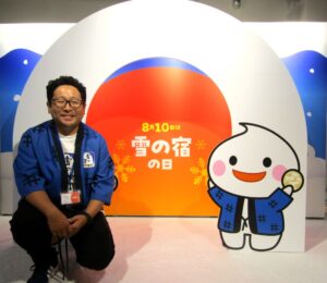 “かまくら”をイメージしたフォトスポットと足立和彦執行役員マーケティング統括部長兼マーケティング部長