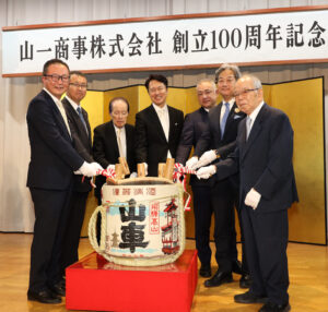 記念式典で山下喜一郎社長（中央）と山下喜八郎会長（左から3人目）を囲んで鏡割り