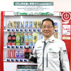 「カーボンオフセット自動販売機」を利用する柴山社長