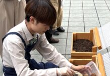 ネスレ日本、カフェで「資源循環を見てもらう」 抽出後のコーヒー粉などよる土づくりを可視化 神戸市・兵庫県立大と連携 「ネスカフェ三宮」の2階テラスに設置したキエーロに使用済み紙製コーヒーポッド(コーヒーグラウンド)を投入するスタッフ