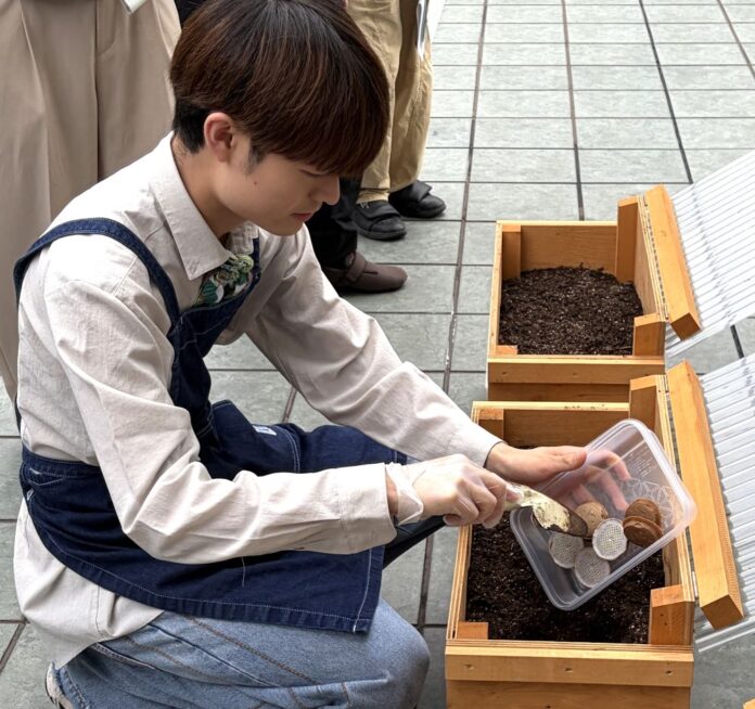 「ネスカフェ三宮」の2階テラスに設置したキエーロに使用済み紙製コーヒーポッド(コーヒーグラウンド)を投入するスタッフ 「ネスカフェ三宮」の2階テラスに設置したキエーロに使用済み紙製コーヒーポッド(コーヒーグラウンド)を投入するスタッフ
