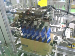 ミルとけ製造工程⑦ケーサーで箱詰めされる様子 「ミルとけ」製造工程⑦ケーサーで箱詰めされる様子