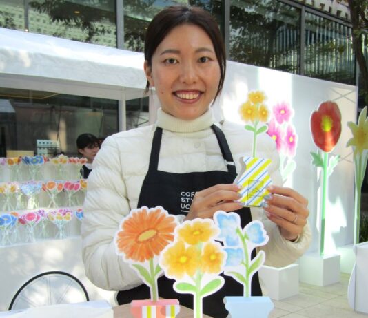 ペーパーフラワーと組み合わせた「CAFE＠HOME」をアピールするCOFFEE STYLE UCCマーケティング企画部主任PR担当の土岐珠世さん