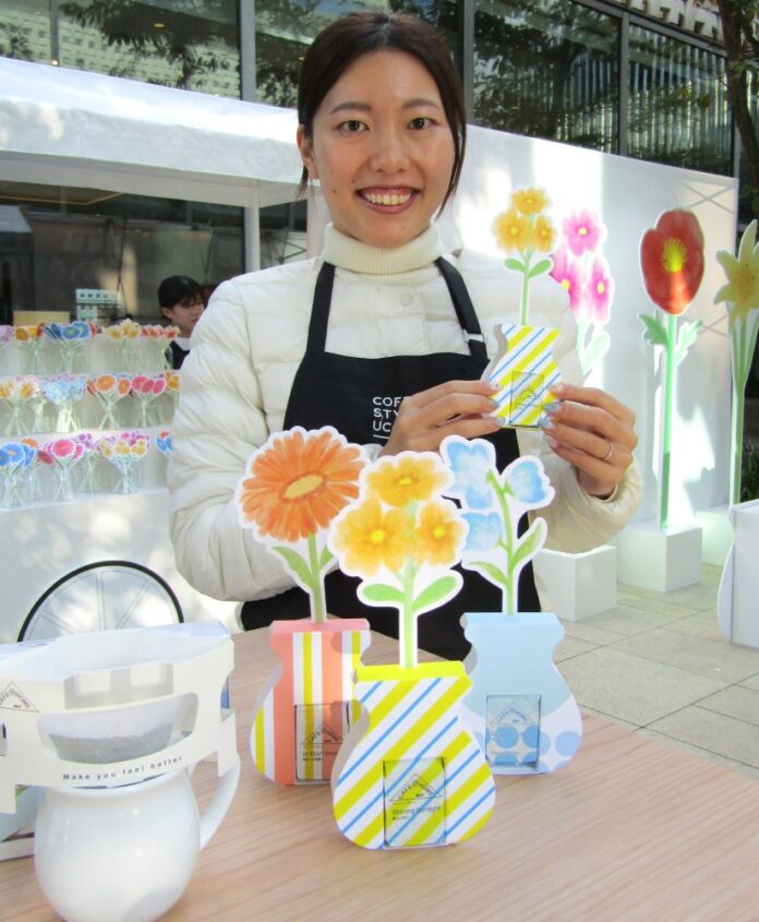 ペーパーフラワーと組み合わせた「CAFE＠HOME」をアピールするCOFFEE STYLE UCCマーケティング企画部主任PR担当の土岐珠世さん