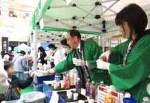 アサヒ飲料「三ツ矢」で過去最大規模の試飲イベント開催 米女社長が有終の美 受け継ぐ近藤次期社長はブランド育成に意欲 イオンモール八千代緑が丘店(千葉県八千代市)で試飲カップを配る米女社長(左)と近藤次期社長(右)