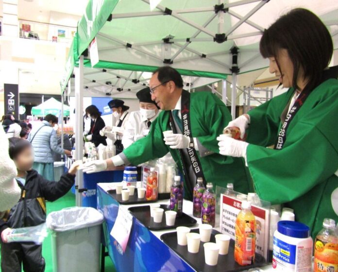 イオンモール八千代緑が丘店（千葉県八千代市）で試飲カップを配る米女社長（左）と近藤次期社長（右）