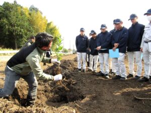 レモンの苗木の定植を指南するポッカサッポロの土屋淳一原料ビジネス推進部部長