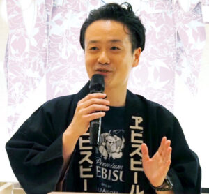 明治時代にヱビスビールの醸造所で実際に使われていたという作業着で登壇した荒木進之介氏