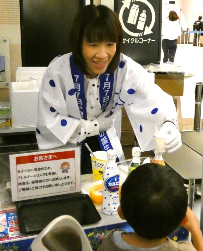 4日、イオンモール幕張新都心店のイベント会場で「カルピス」入りヨーグルトを手渡す近藤佳代子社長