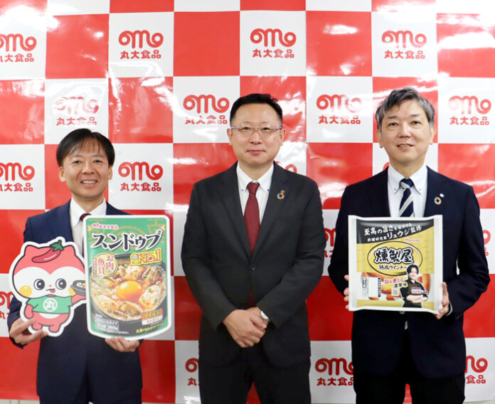 発表会で小瀬川竜哉上席執行役員㊥ら。左端のキャラクターが「ドゥブ丸」