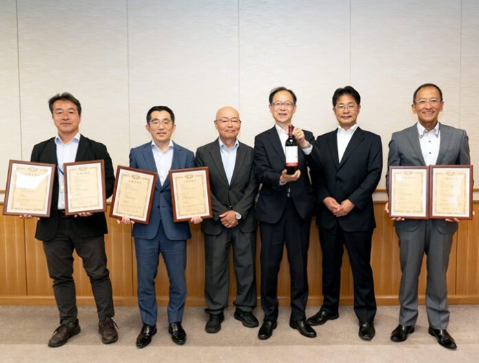 記念撮影 （左から釘宮伸明大分県農林水産研究指導センター　果樹グループ　グループ長、鈴木辰洋　同　センター次長、尾野賢治大分県副知事、佐藤樹一郎大分県知事、西和紀三和酒類社長、古屋浩二　同　執行役員　安心院葡萄酒工房工房長）