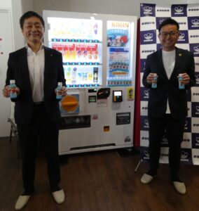 左からキリンビバレッジの芳野博郎執行役員営業統括本部自販機営業本部長とバディ企画研究所の山本大祐取締役