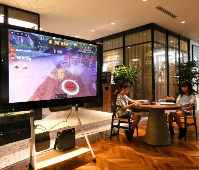 デモンストレーションで「BECOME A COFFEE FARMER」に興じる、こうきくん（左）とかやちゃん（右）