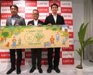 シェードツリーの1つココナッツの苗木（右）と左から宮野啓治執行役員、生産本部資材部の久保直樹部長、サステナビリティ推進部企画課の飯田智晴課長