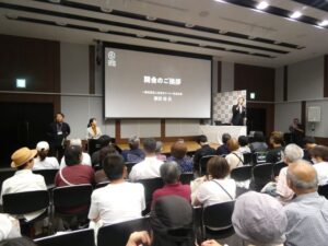 講演コーナーで主催者挨拶する柴田会長
